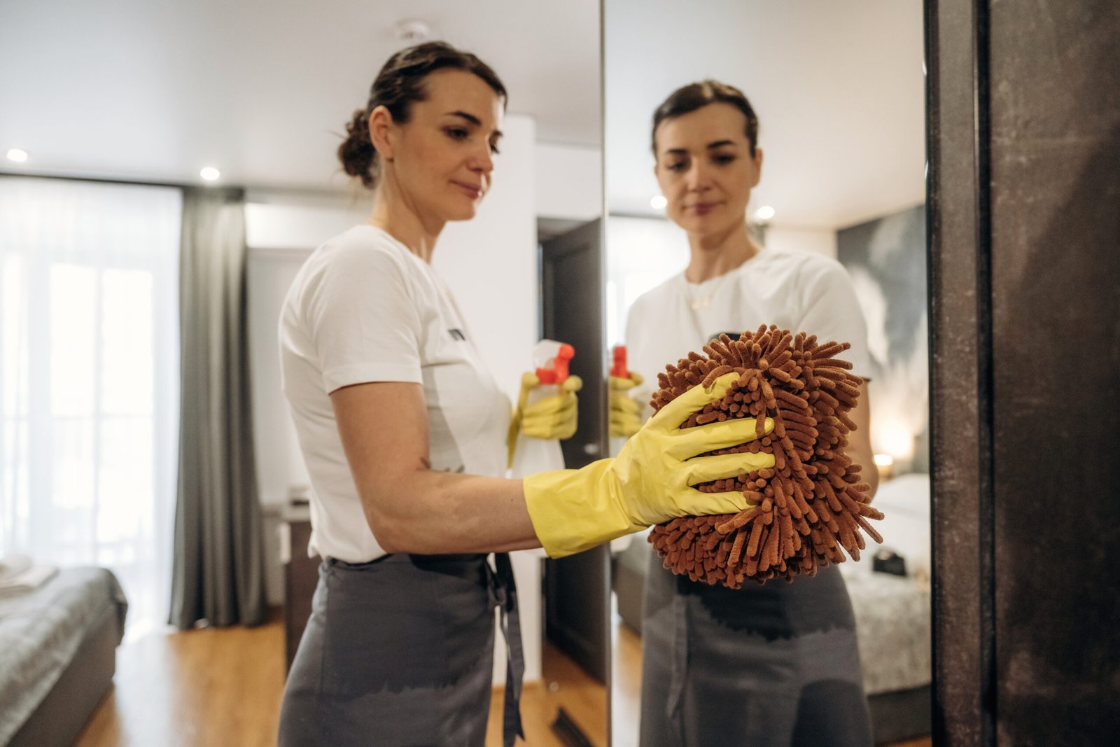 female hotel cleaner in yellow gloves dusting a mi 2026 04 24 04 19 03 utc scaled