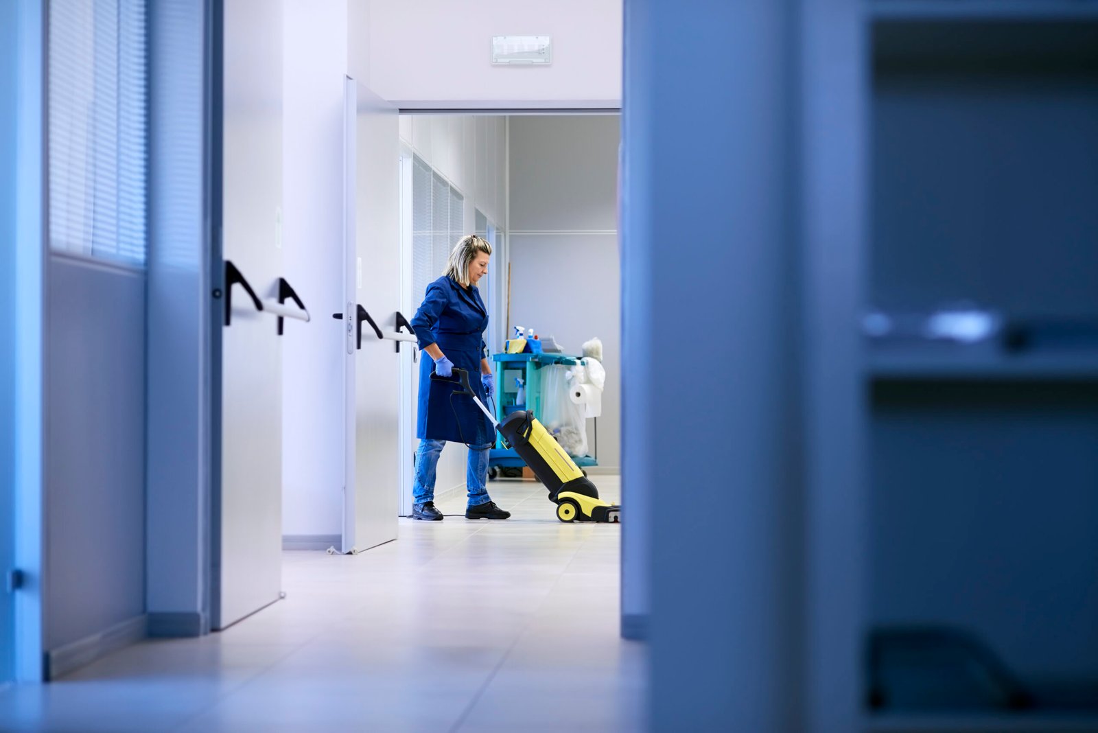 woman cleaning office hallway with vacuum cleaner 2026 03 17 00 49 10 utc scaled