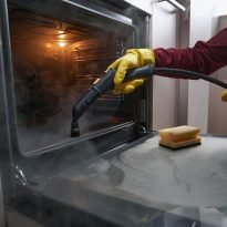 Experienced,Worker,In,Rubber,Gloves,Steam-cleaning,Kitchen,Equipment