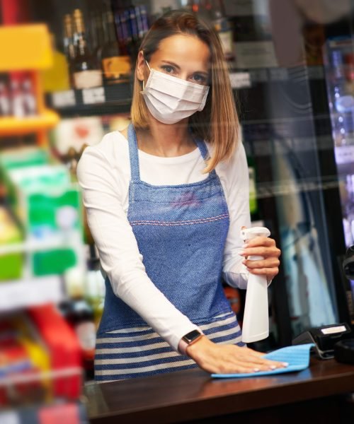 Picture of shop assistant disinfecting surfaces in grocery store